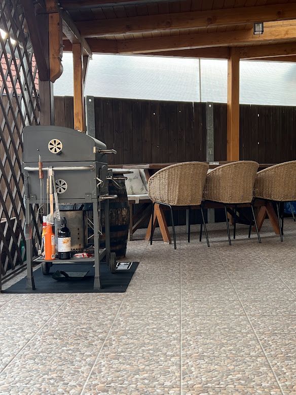 Überdachte Terrasse mit Grill und Sitzgelegenheit im Apartment U Krčků, Südmähren
